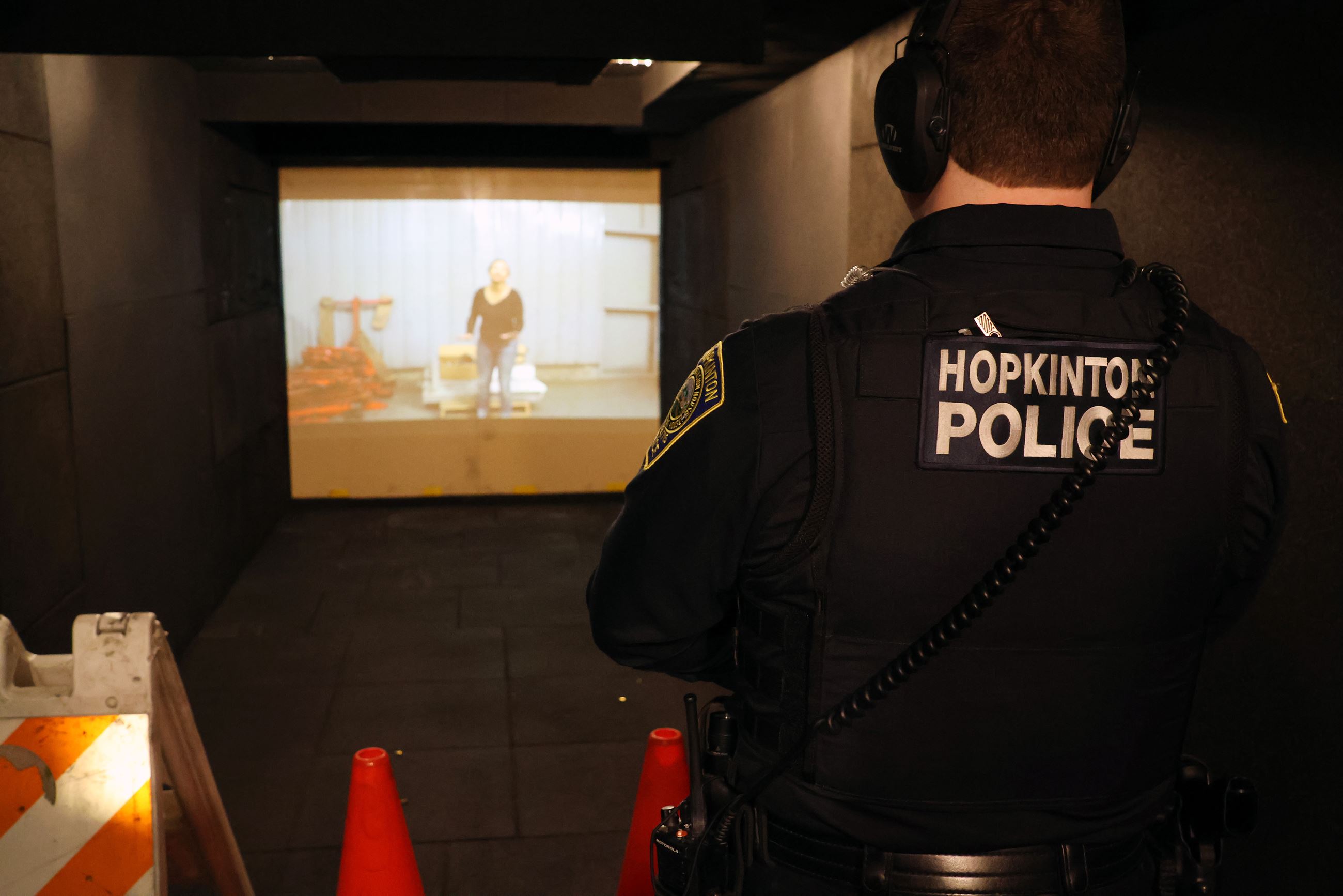 A Hopkinton Police Officer faces a screen inside the Mobile Training Center.
